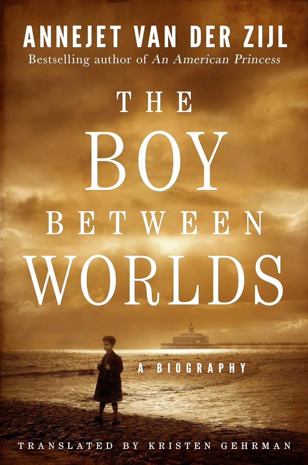 Cover of “The Boy Between Worlds” by Annejet van der Zijl, featuring a sepia-toned image of a young boy standing on a beach with a ship in the background, under dramatic skies. The subtitle reads: A Biography.