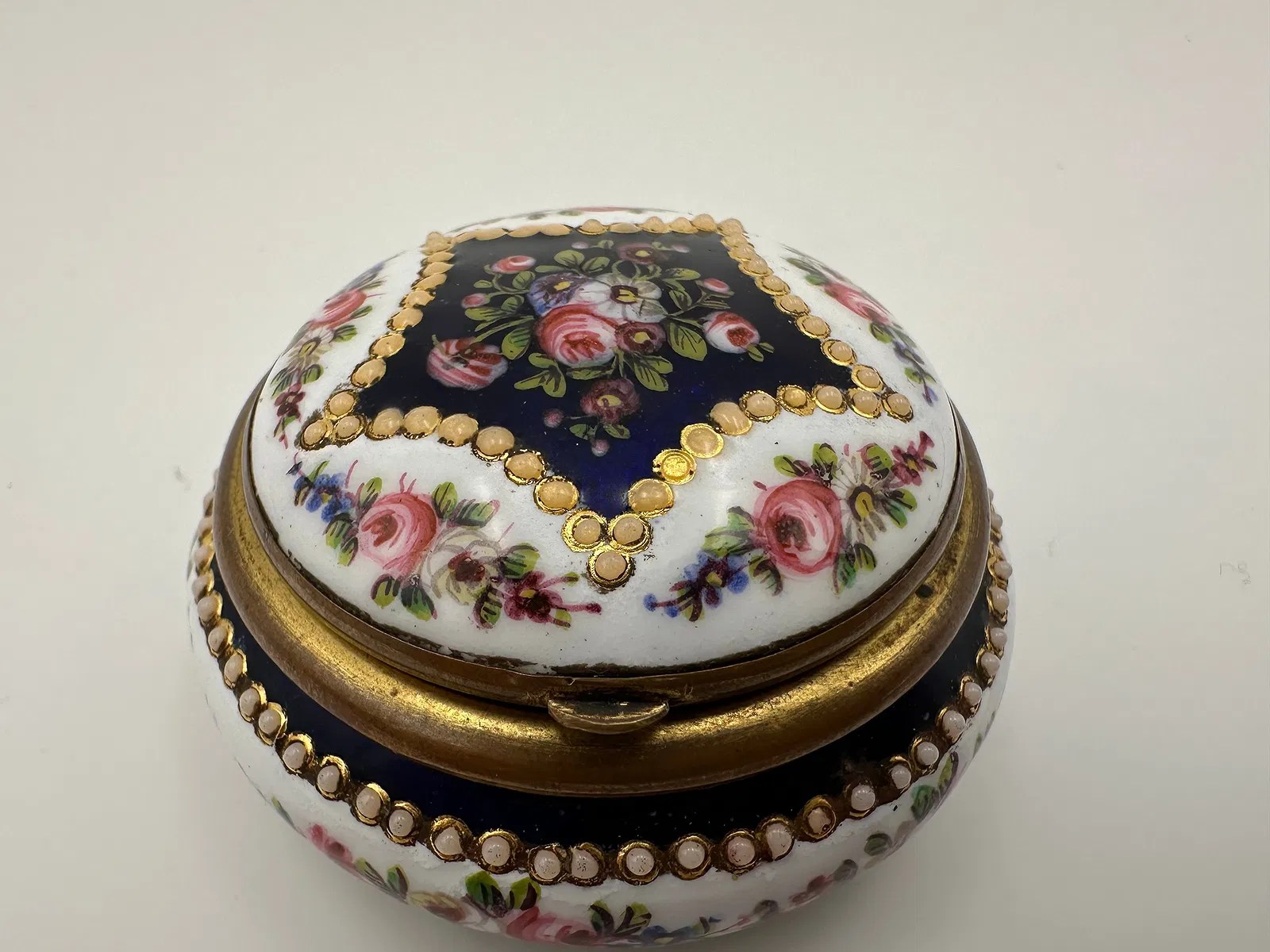 Swiss round hand-painted enamel snuff box with floral decoration, 19th century