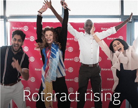 Four people celebrating with raised hands in front of a red Rotaract backdrop with text "Rotaract rising"