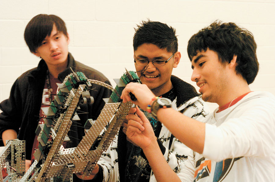 From left, Billy Liu, Lord Nicklyn Labiano, and Javier Guerra, all students at Cross Keys High School, put finishing touches on their team’s robot built in the “pits,” before they demonstrate its capabilites in the school’s gymnasium on Feb. 11.