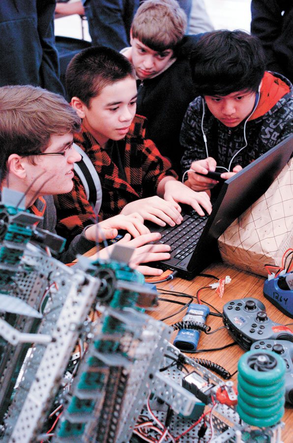 From left, Trey Brooks, Derek Santisteban, Michael Frost and Wilson Pu, Dunwoody High School students, program their robot.