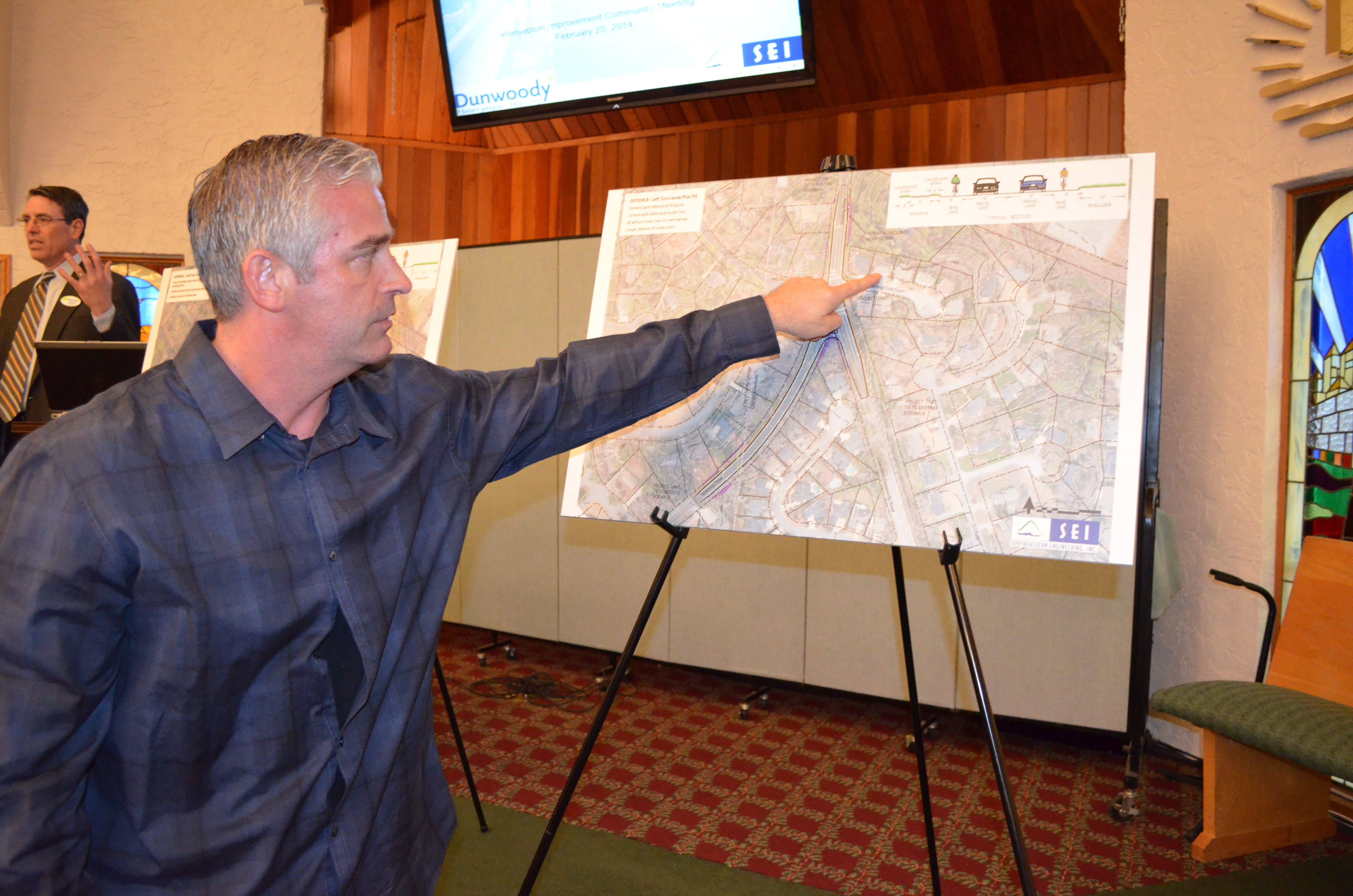 Jeff Kline points to map showing proposed improvements to intersection at Chamblee Dunwoody Road and Spalding Drive near his home. Kline was among residents attending a public meeting held Feb. 25 by Dunwoody city officials at New Apostolic Church to discuss ways to improve safety at the intersection.