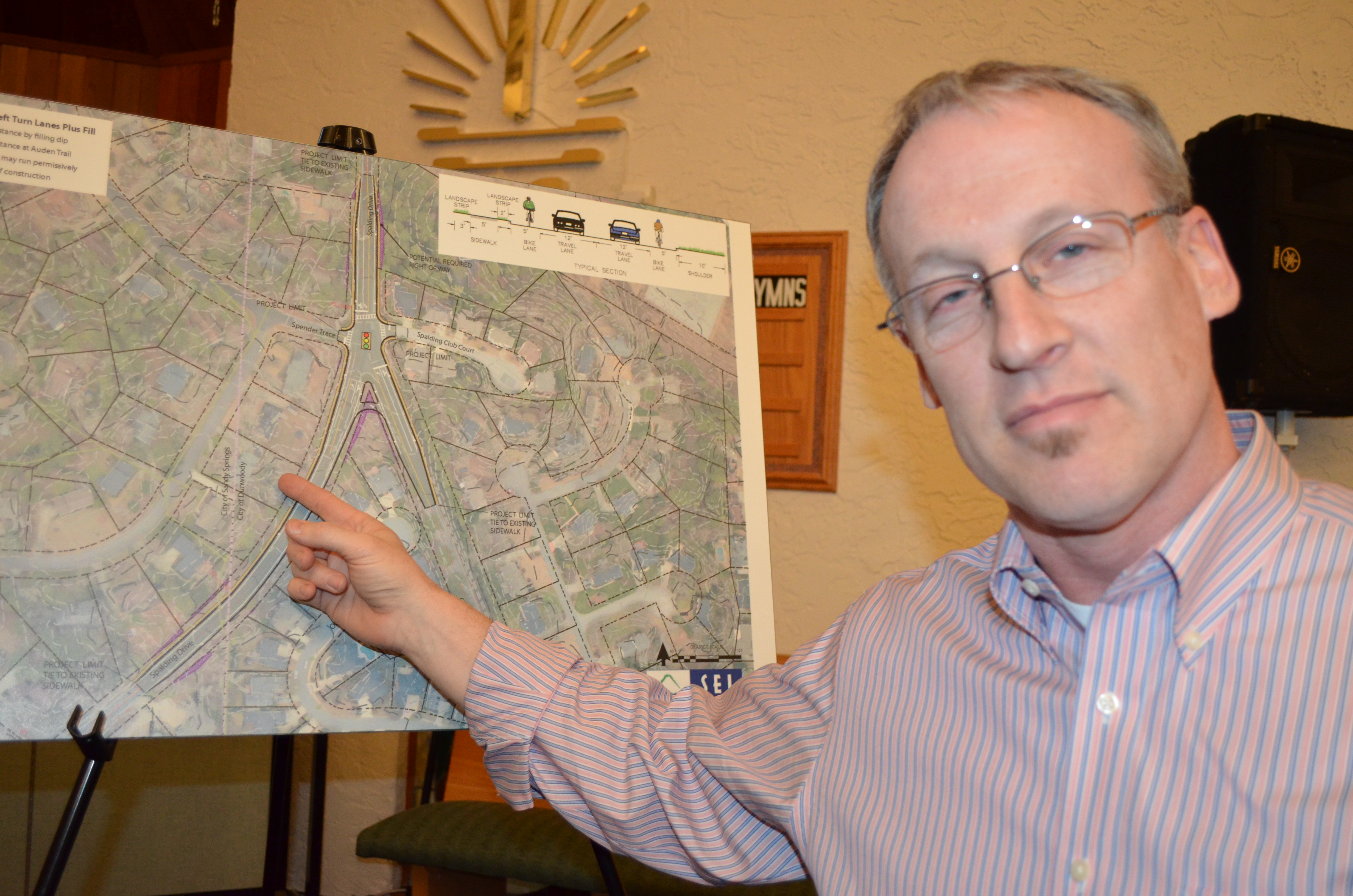 Mark Baker points out the location of his home on map showing proposed improvements to intersection at Chamblee Dunwoody Road and Spalding Drive. Baker was among residents attending a public meeting held Feb. 25 by Dunwoody city officials at New Apostolic Church to discuss ways to improve safety at the intersection.