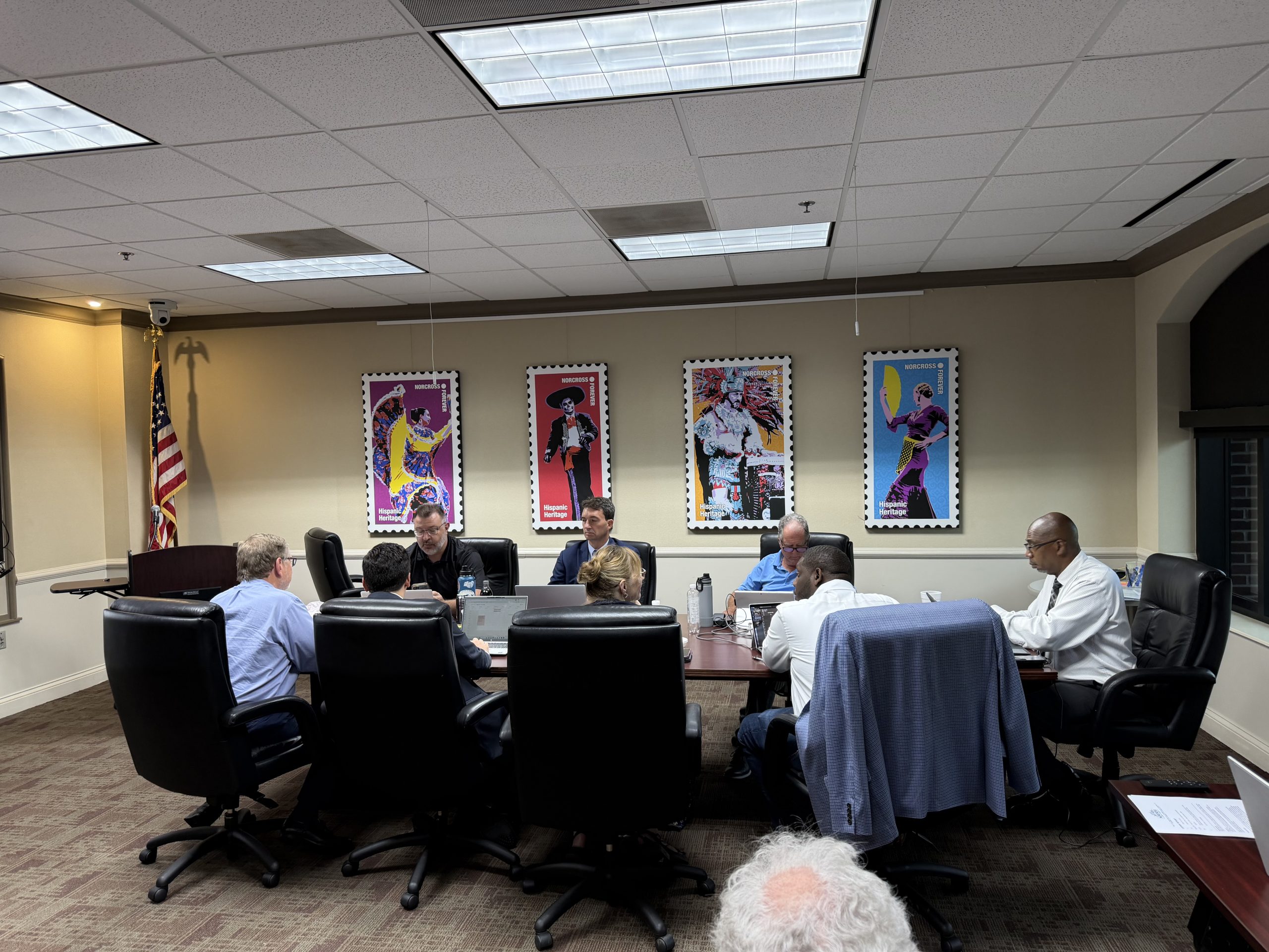 Norcross City Council members discuss agenda items at council chamber meeting table