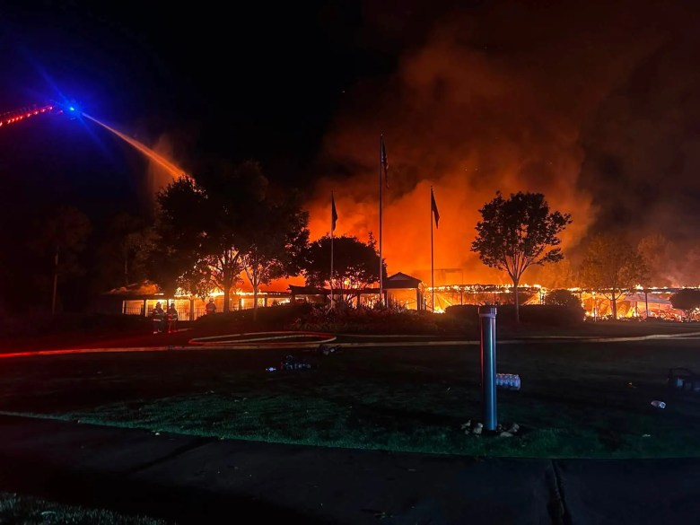 Greene County Fire Rescue crews battle a large nighttime fire as a ladder truck sprays water on the burning building