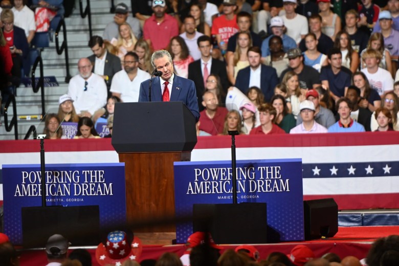 Rick Jackson speaks at a Trump rally in Marietta, Georgia, at a podium flanked by ‘Powering the American Dream’ signs.
