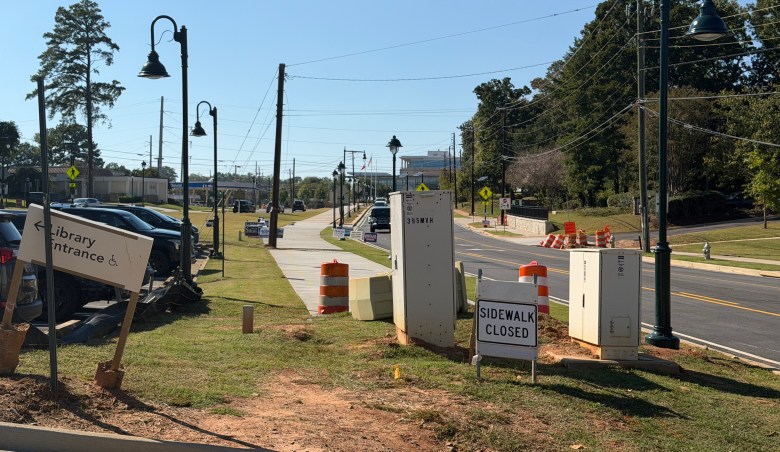 Sidewalk Closed sign and utility boxes near Sandy Springs Library entrance during Mount Vernon Highway construction