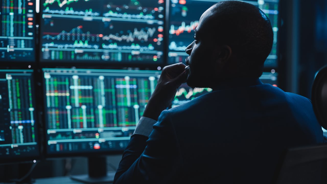 IT professional looking at patterns on multiple computer screens