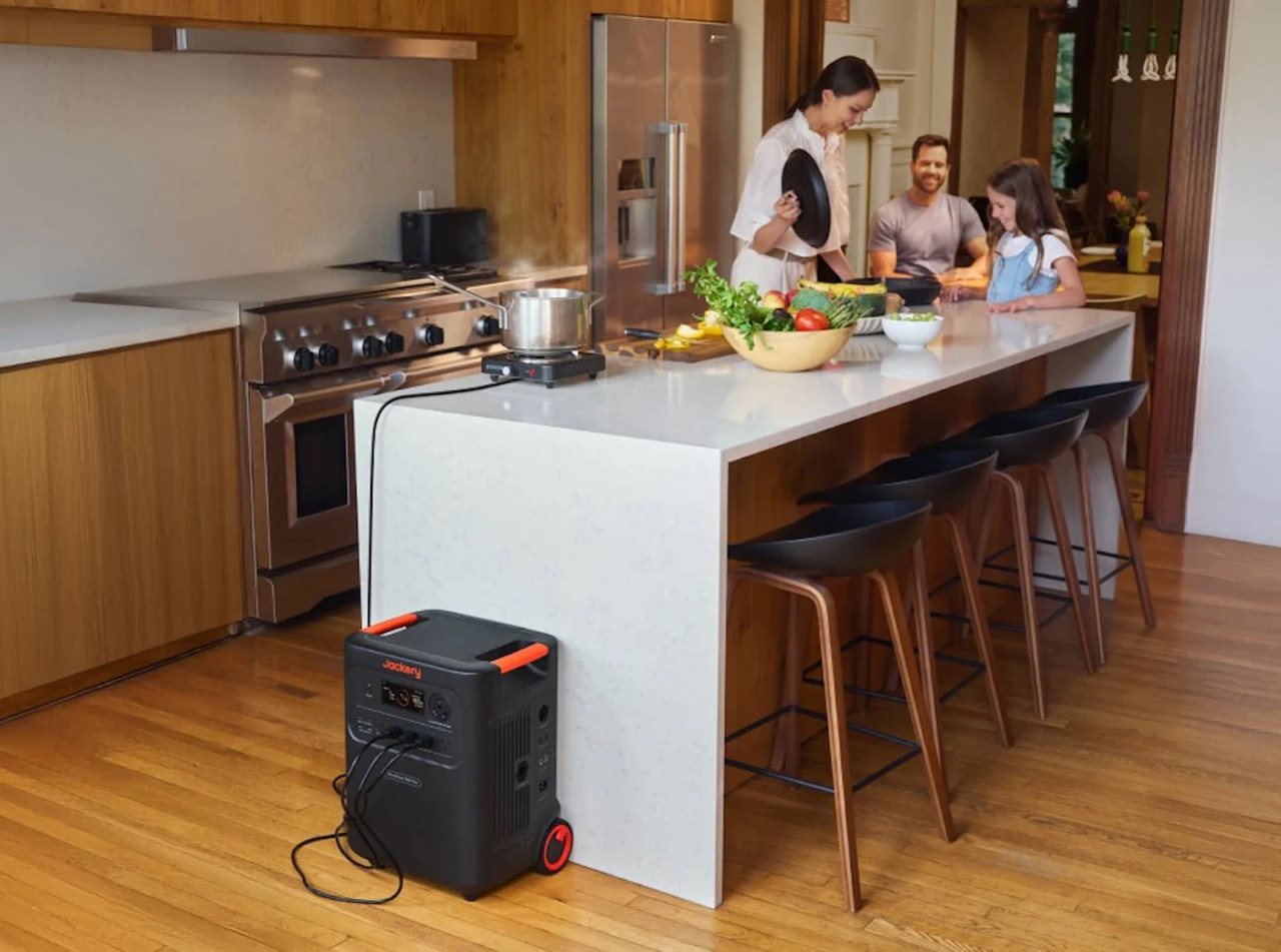 Family preparing dinner in kitchen while using the Jackery Home power 3600 to powering a hot plate.