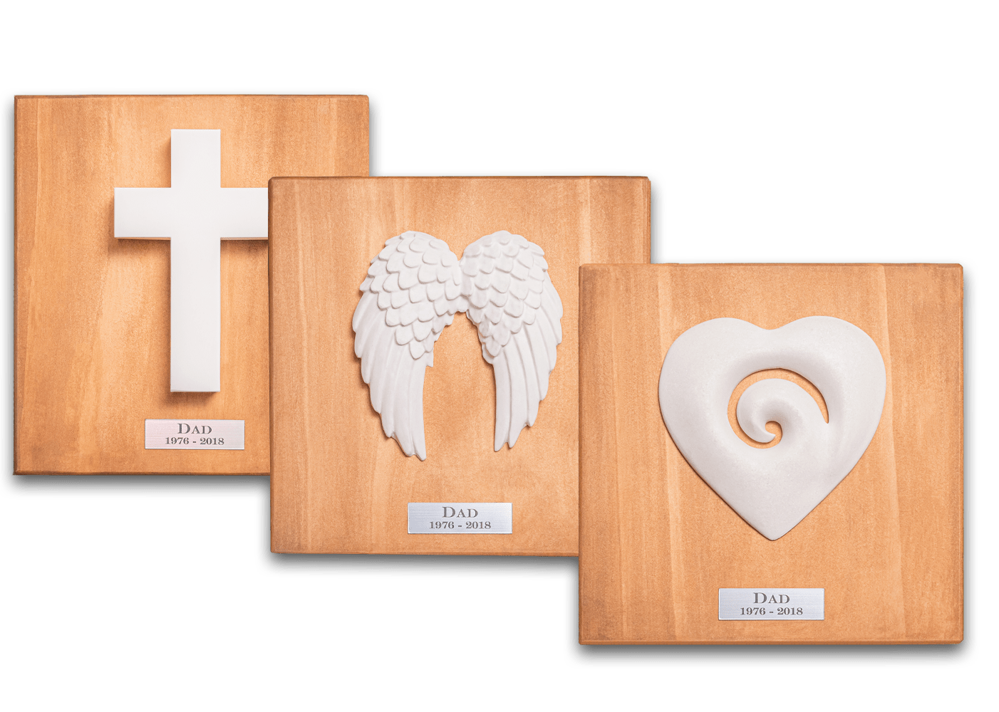 Memorial ornaments — cross, angel wings, and koru heart on wooden boards