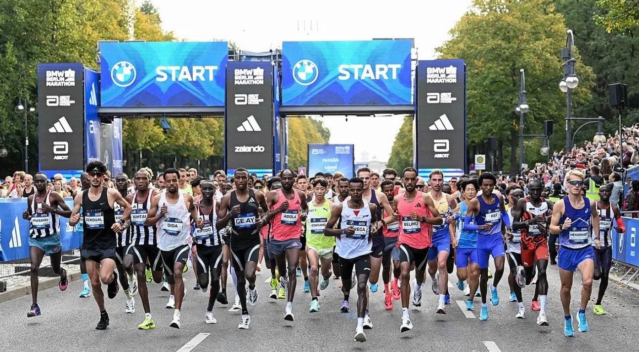 Runners at the Berlin Marathon start beneath BMW-branded start gantries