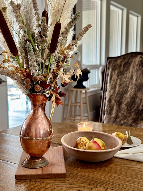 copper pitcher holding foraged autumn florals