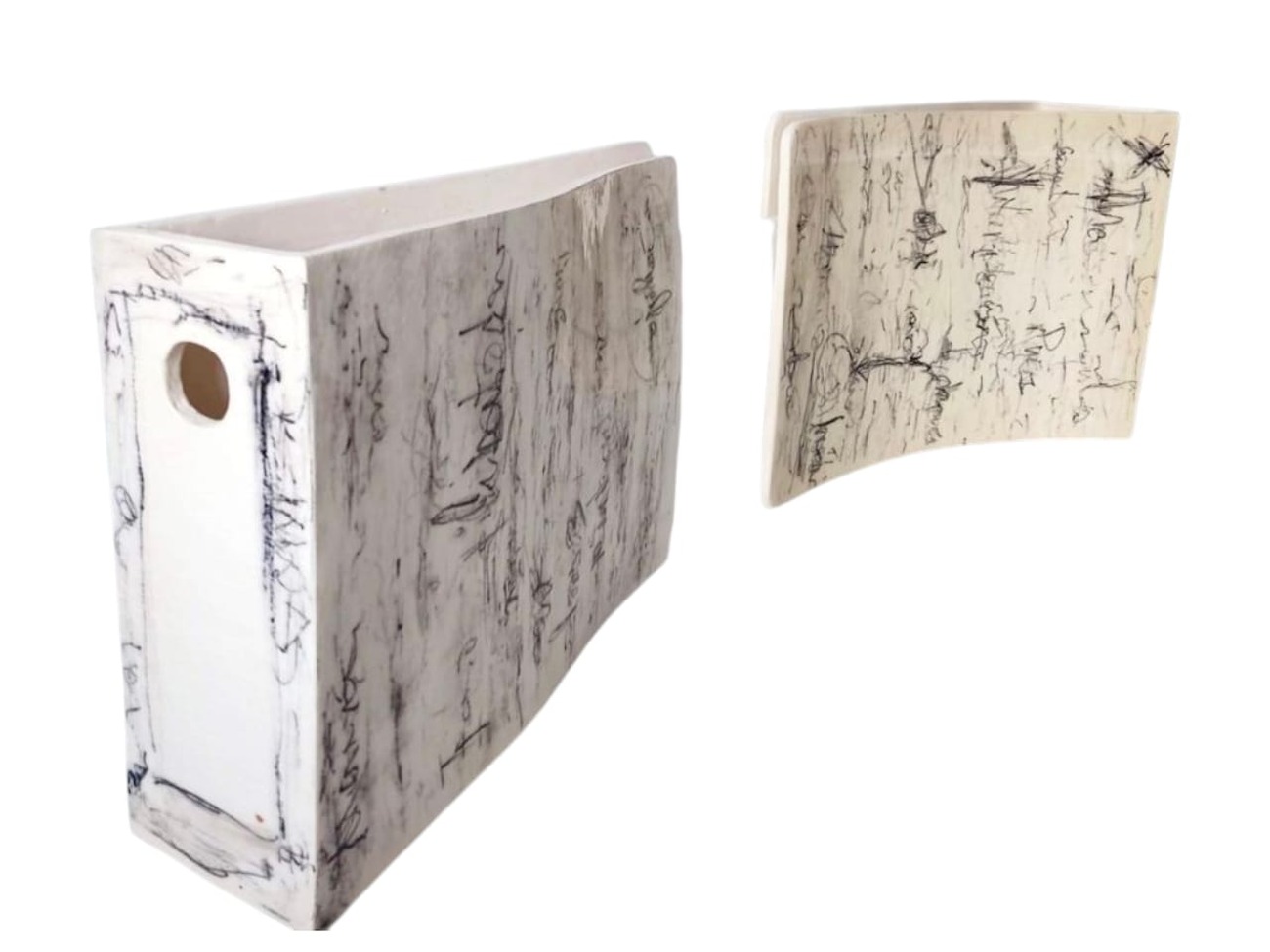 Entrelazadas: pieza cerámica en forma de carpeta o cuaderno curvado, en blanco crudo, con un pequeño orificio ovalado y toda la superficie cubierta de escritura cursiva incisa