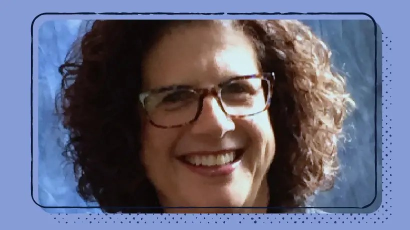 Una mujer sonriente con gafas sobre un fondo morado.