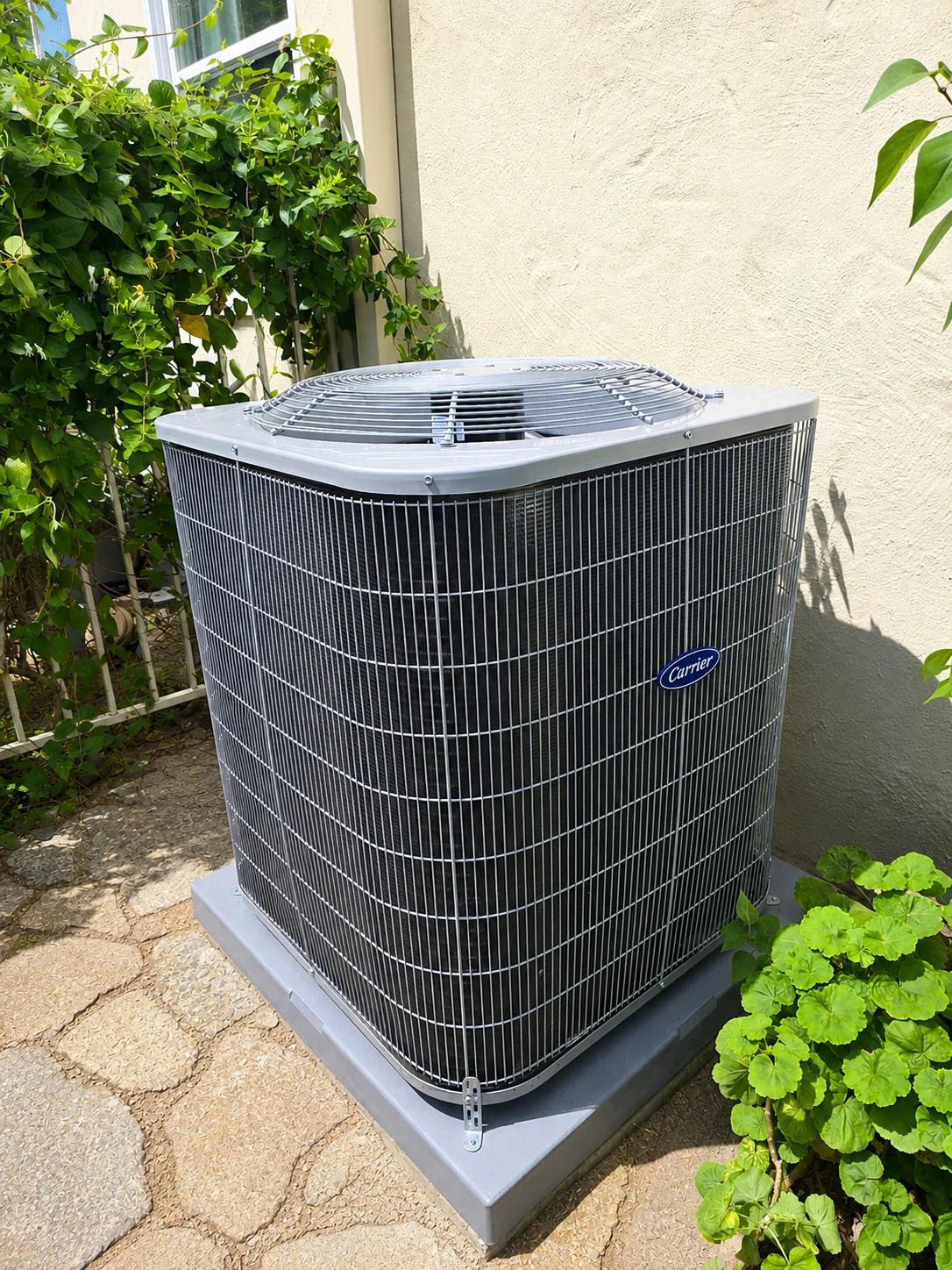 Carrier outdoor air conditioning condenser installed beside a home