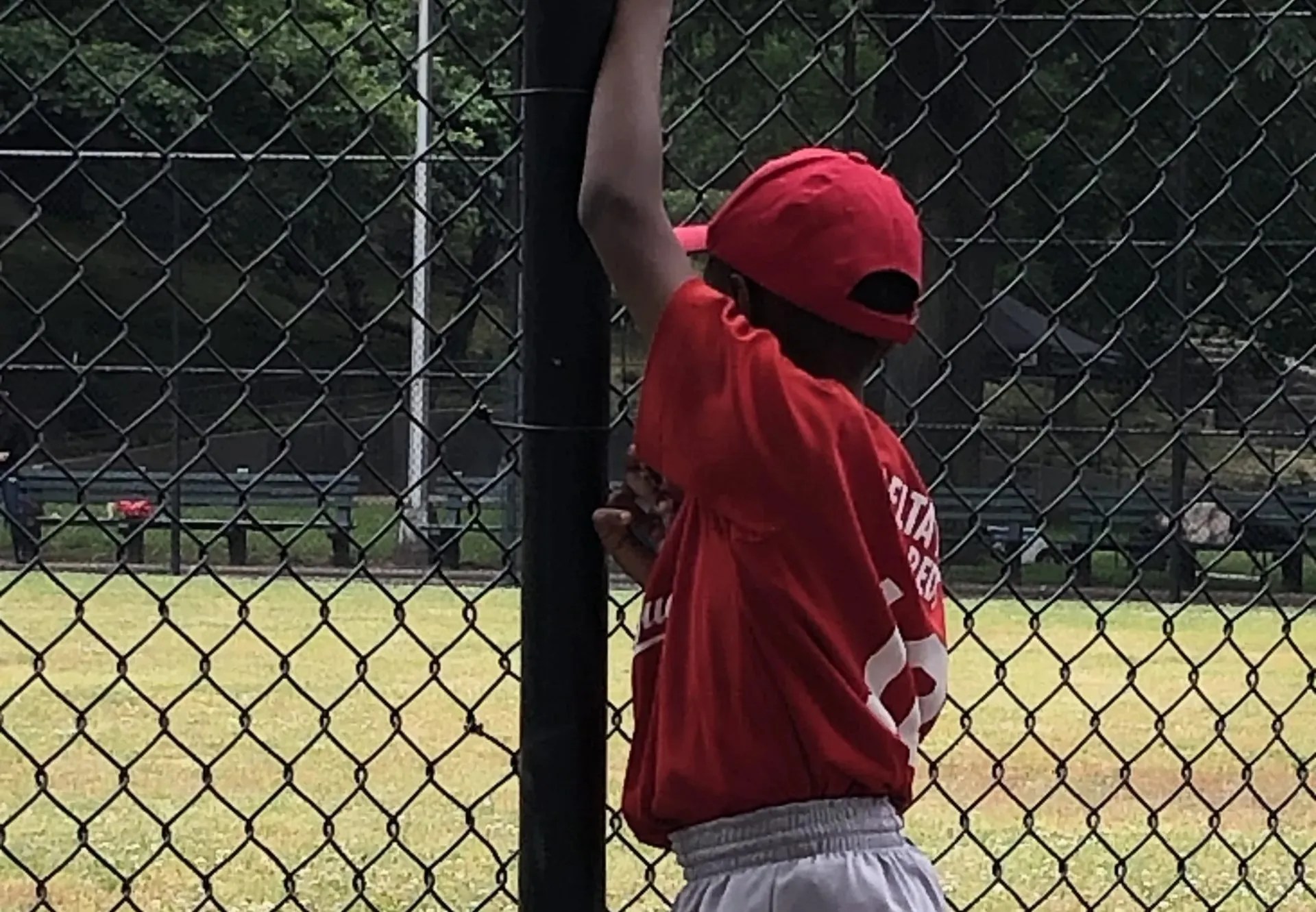 Harlem Little Leaguer watches from the fences. Credit: Satrina Boyce/New York Amsterdam News