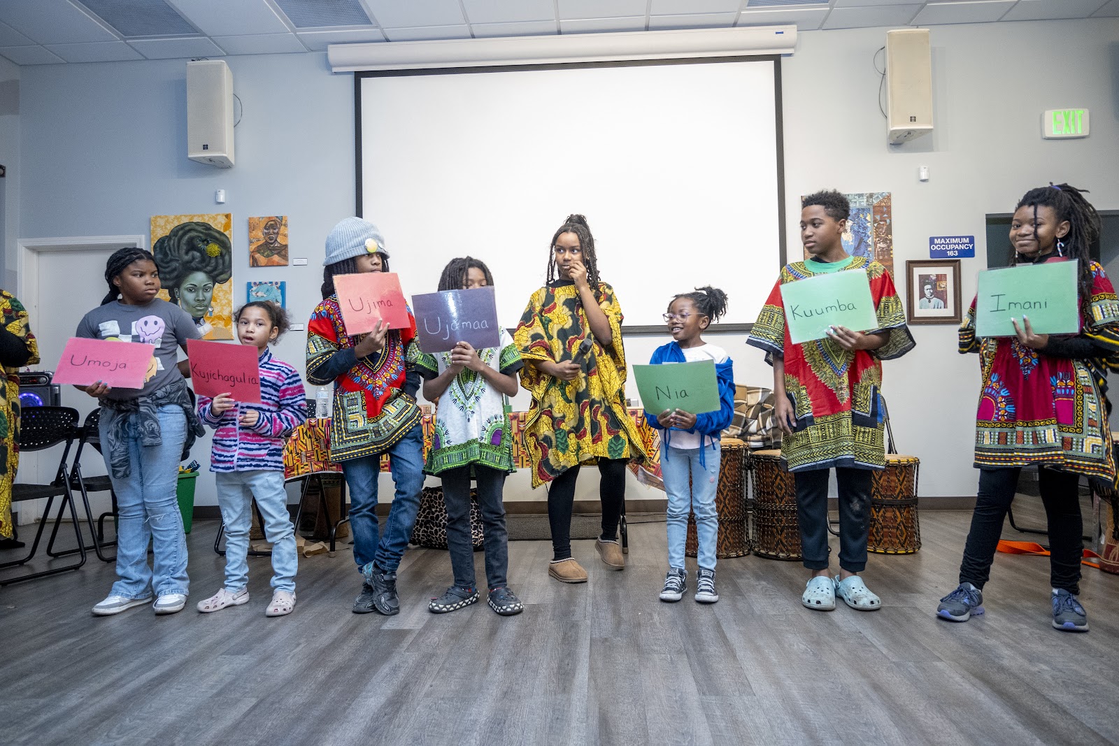 Scholars from the Melanin Day School Academy lined up to show what each Kwanzaa candle represents during the 2024 Children’s Kwanzaa Celebration. Russell Stiger Jr., OBSERVER