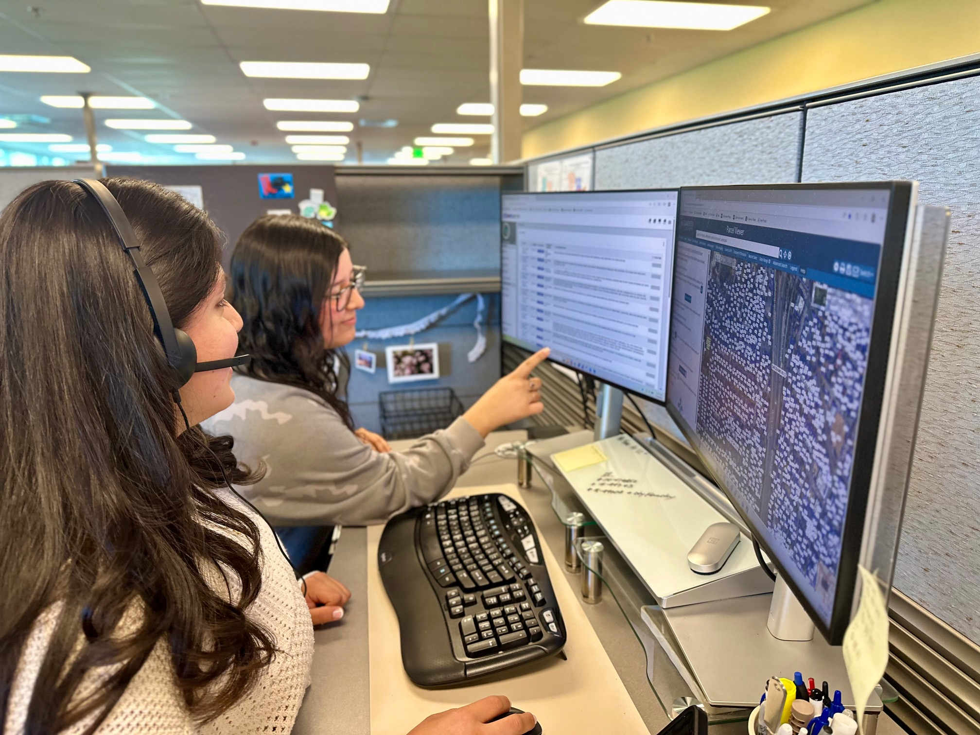 Two code liaison office staff looking at a computer monitor