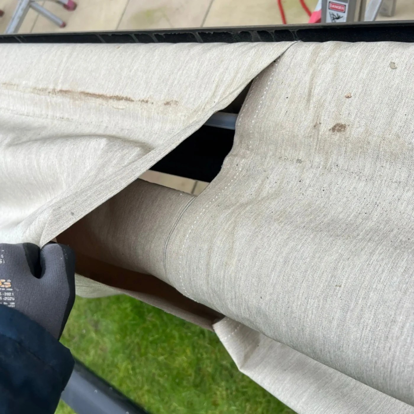 close up of torn awning fabric before replacemen