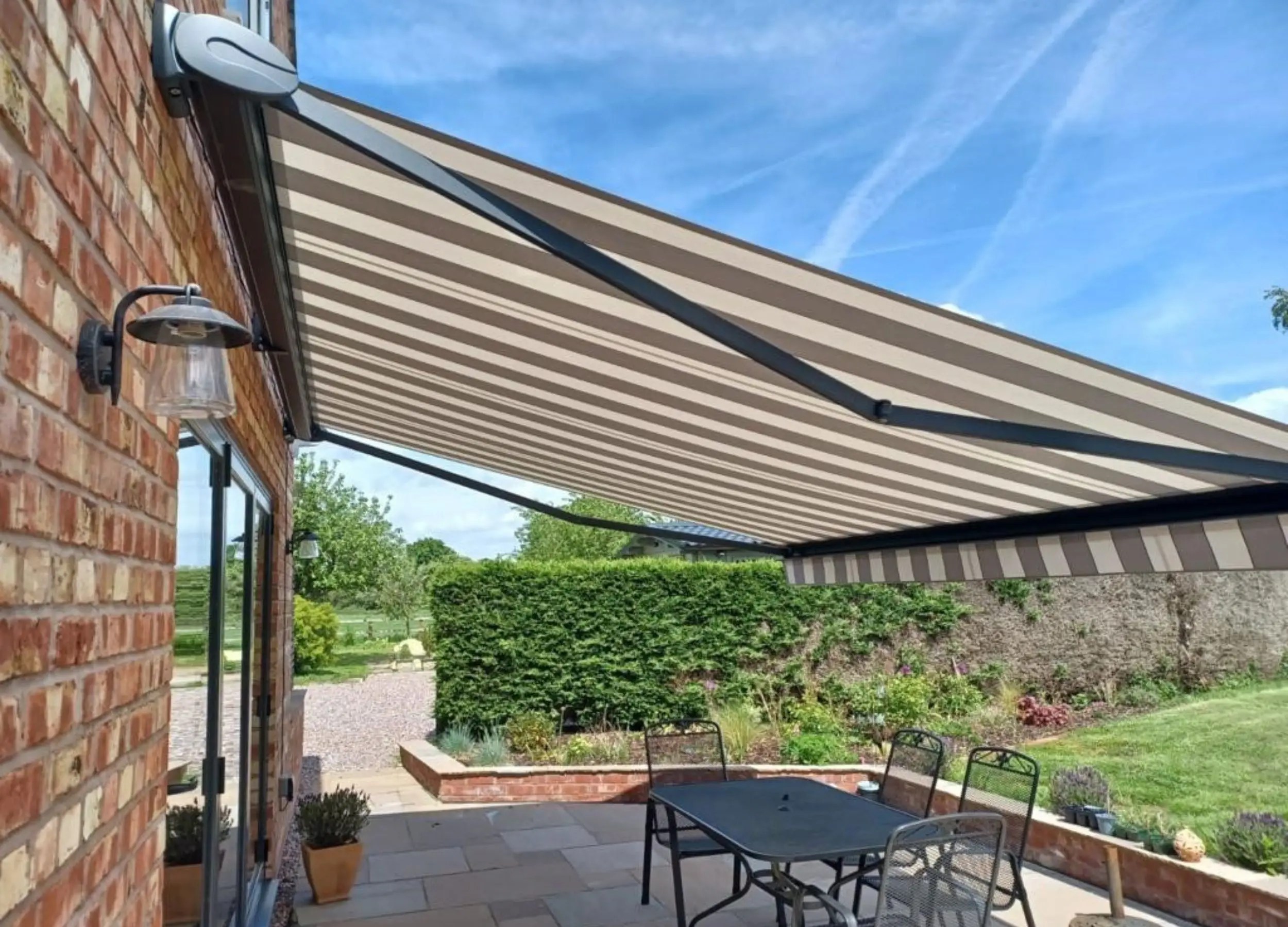 Side view of extended Saffron Signature Quendon awning with striped canopy.