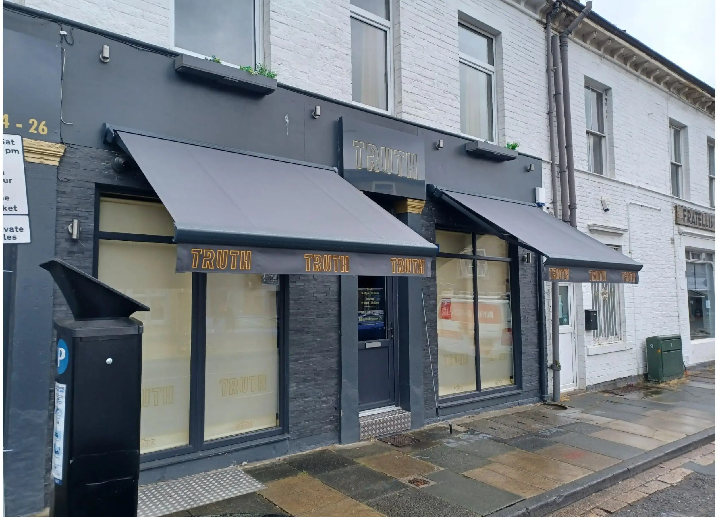 Saffron Signature Kentmere awnings installed at Truth café with branded fabric.