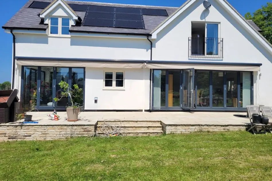 Dual Weinor Opal Design II awnings extended across modern patio with large bifold doors