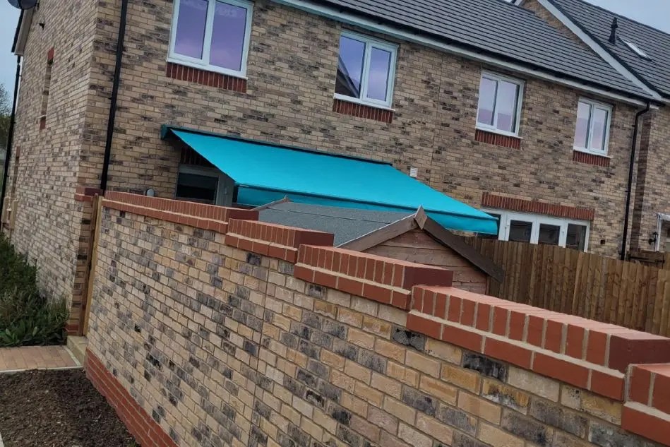 Weinor Topas awning viewed over garden wall in Ely