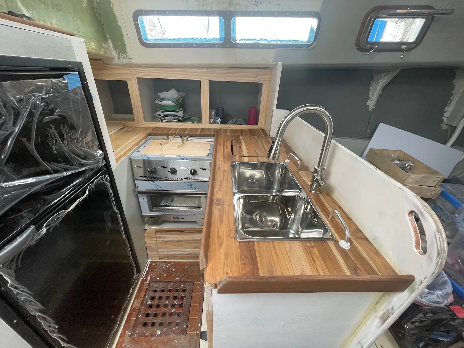 Upright refrigerator, stove, wooden counters and sink during the galley rebuild