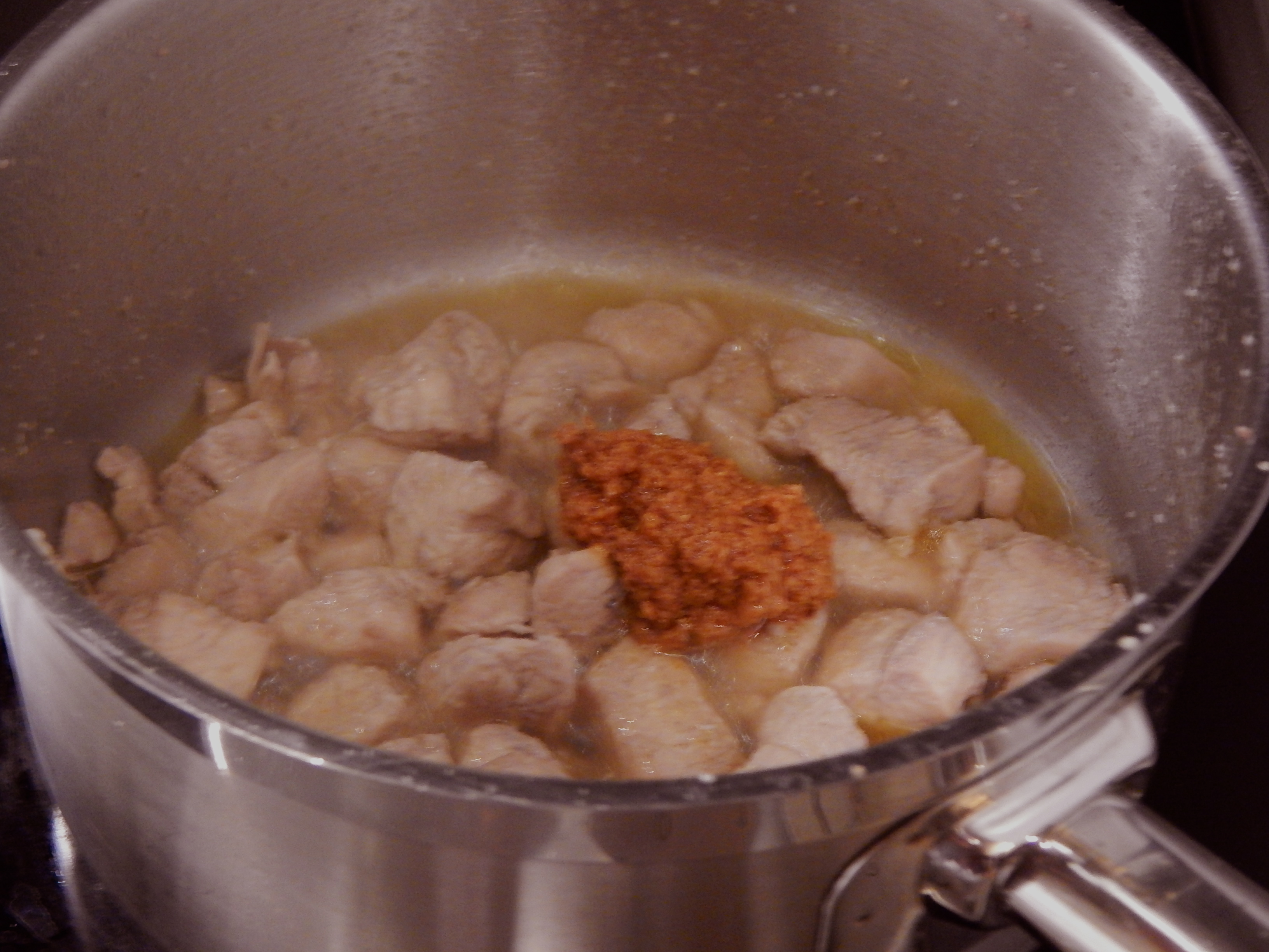 Frite e cozinhe o frango, junte tomate concentrado