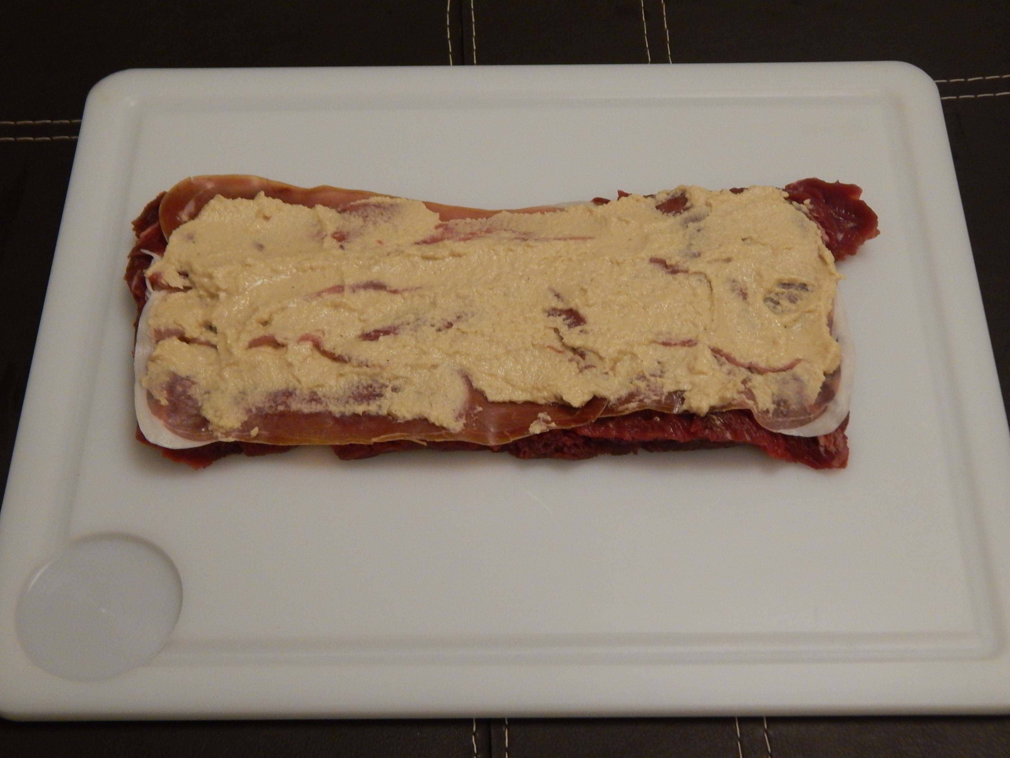 coloque as fatias de presunto e depois o homus sobre o filé aberto