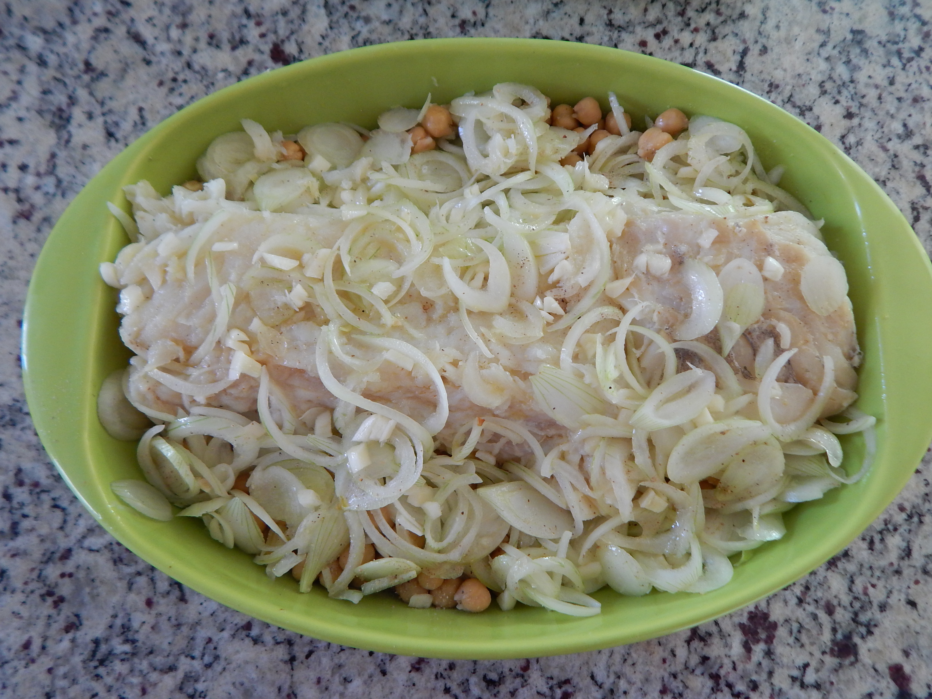 Cubra com cebola, repolho, alho e grão de bico envolvendo o bacalhau