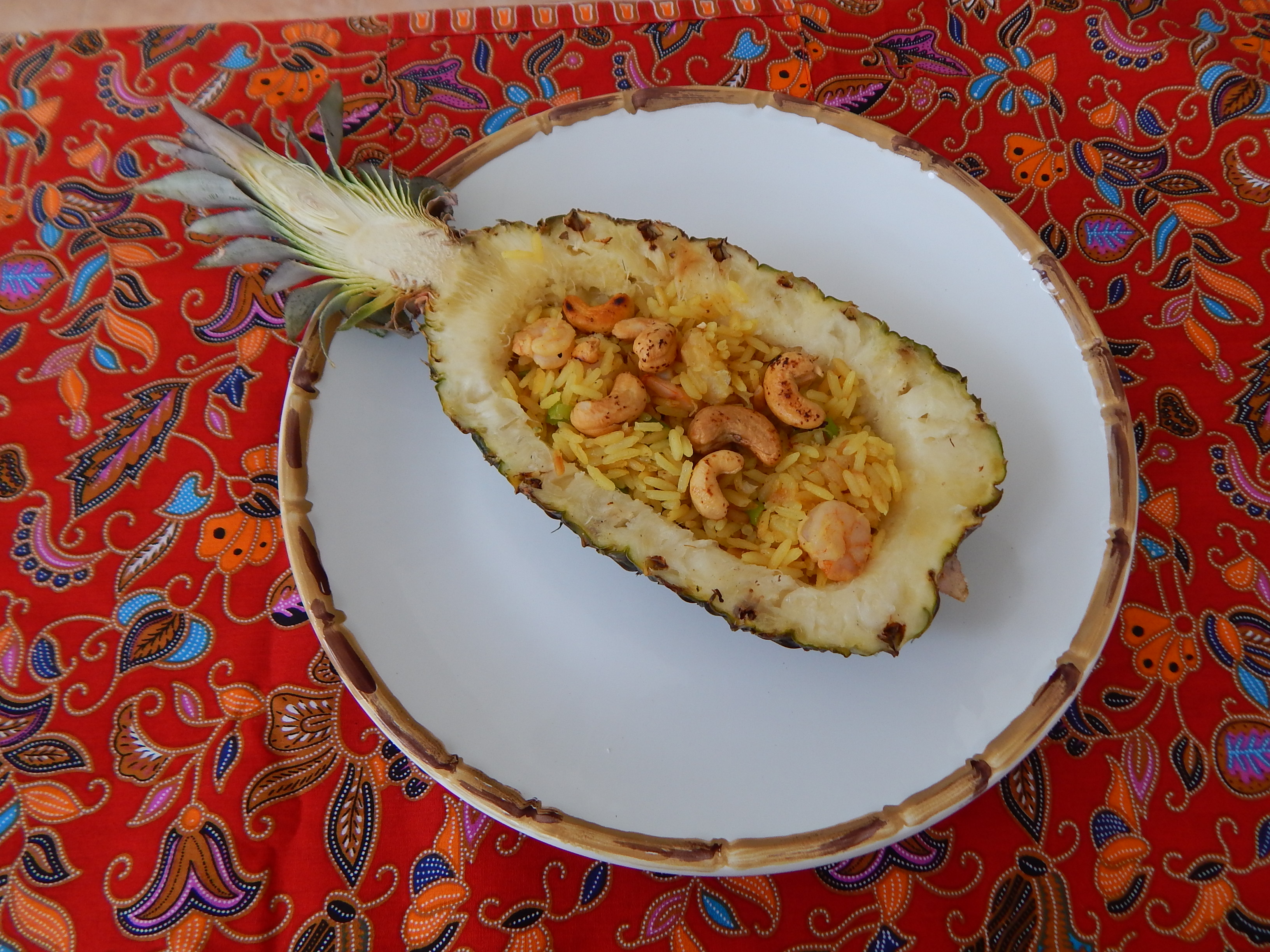 Junte o camarão, recheie o abacaxi e espalhe as castanhas