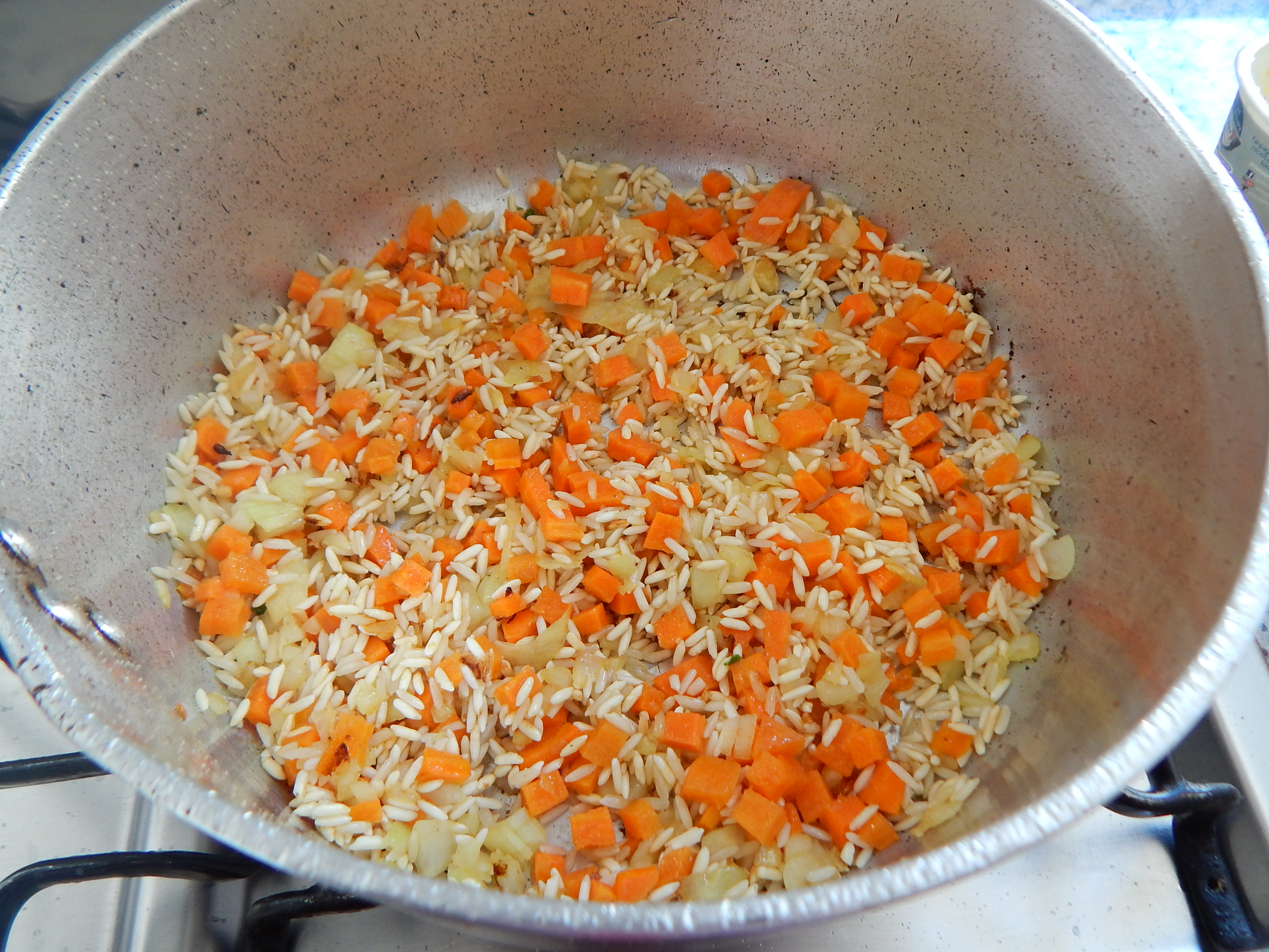 Frite o arroz com o sal com alho e os legumes