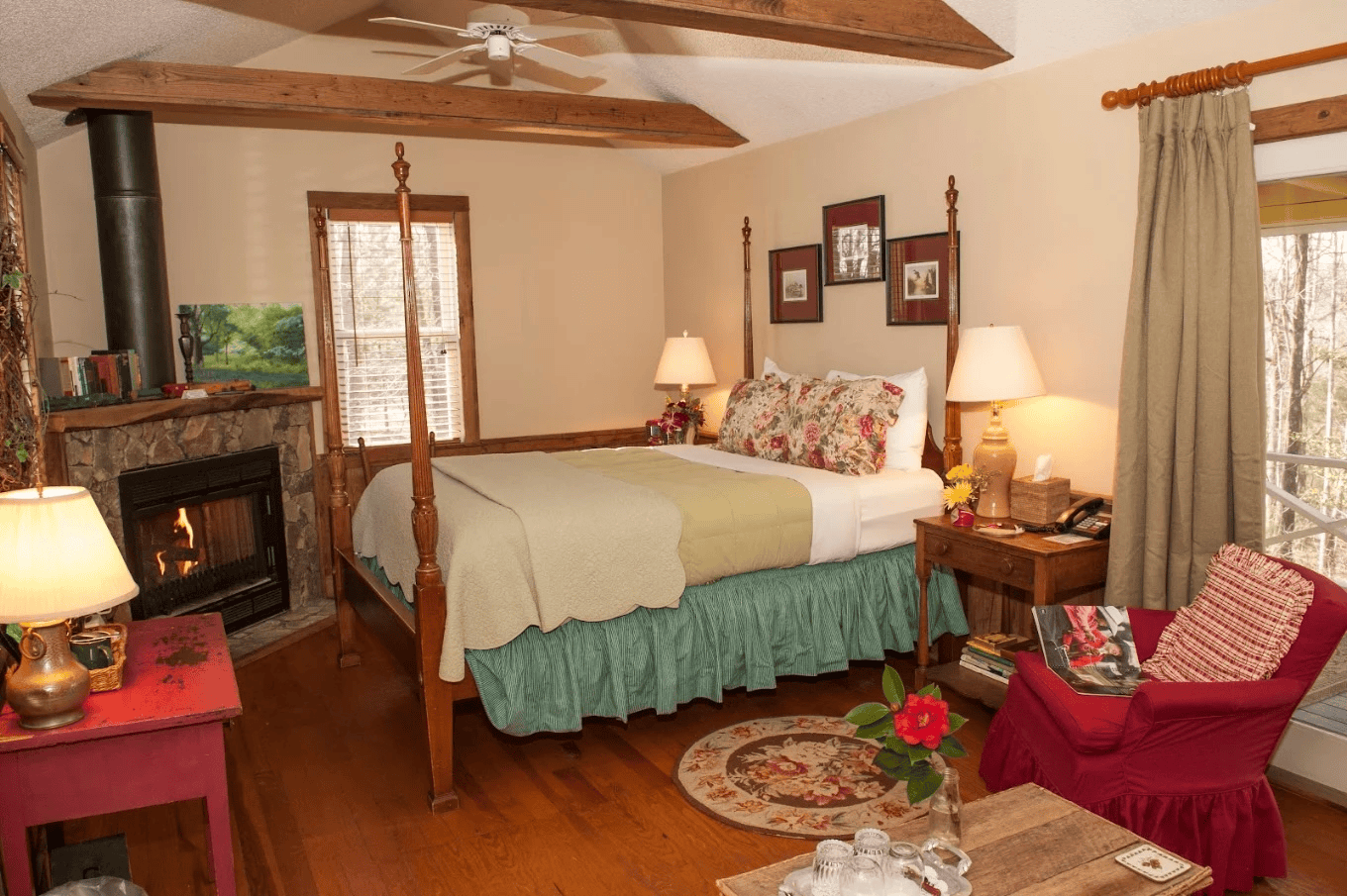 Cozy rustic bedroom with a four-poster bed, wood beams, and a stone fireplace glowing softly.