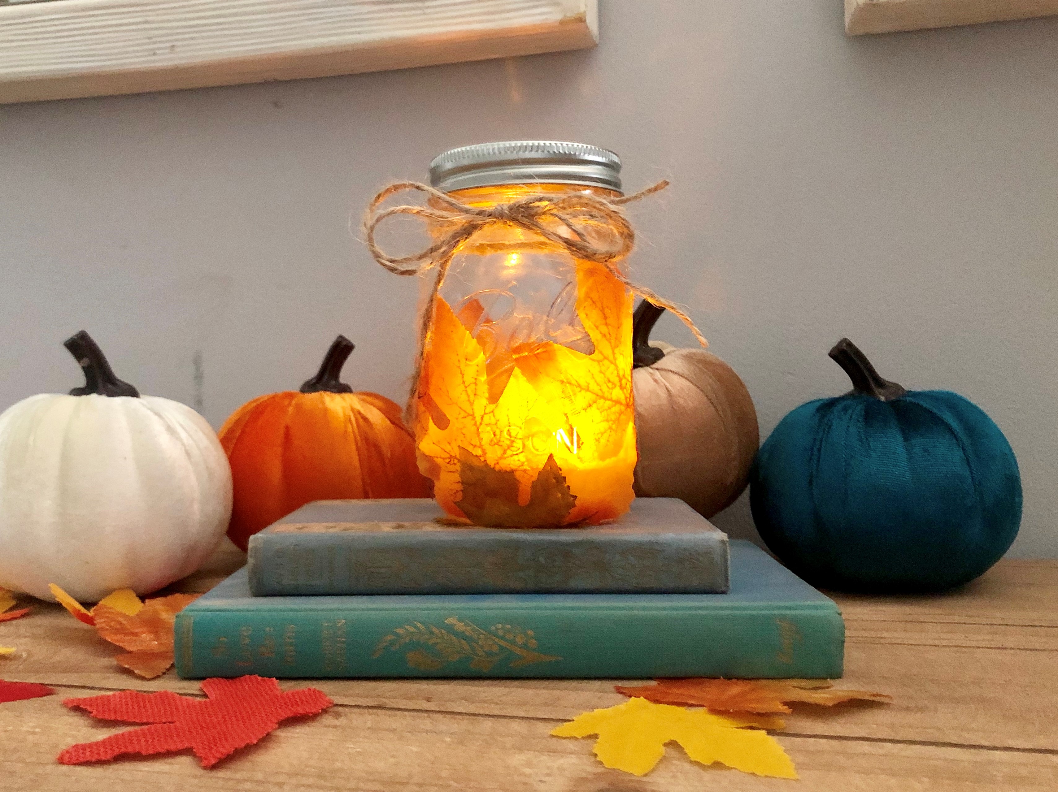 LED mason jars with tea lights and covered with fall leaves will leave a beautiful illuminance in you entry way