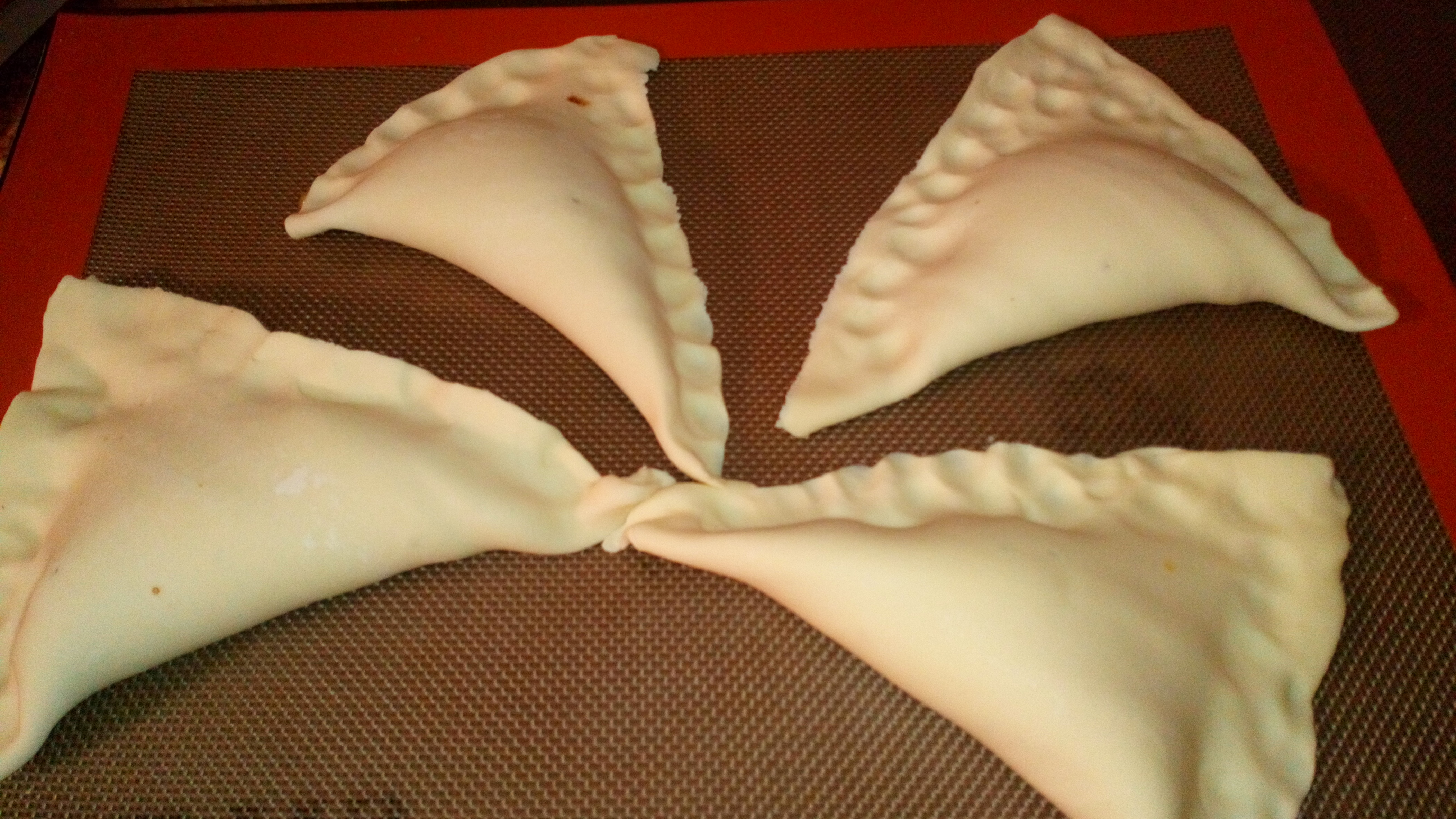 Pour former les chaussons, il faut ramener les deux pointes arrière au-dessus de la compote et serrer progressivement avec les doigts en évitant que la compote ne s'échappe. mettre à plat les chaussons pour bien souder. To close, bring up the back extremiities up to the jam, and press progressivly with the fingers.