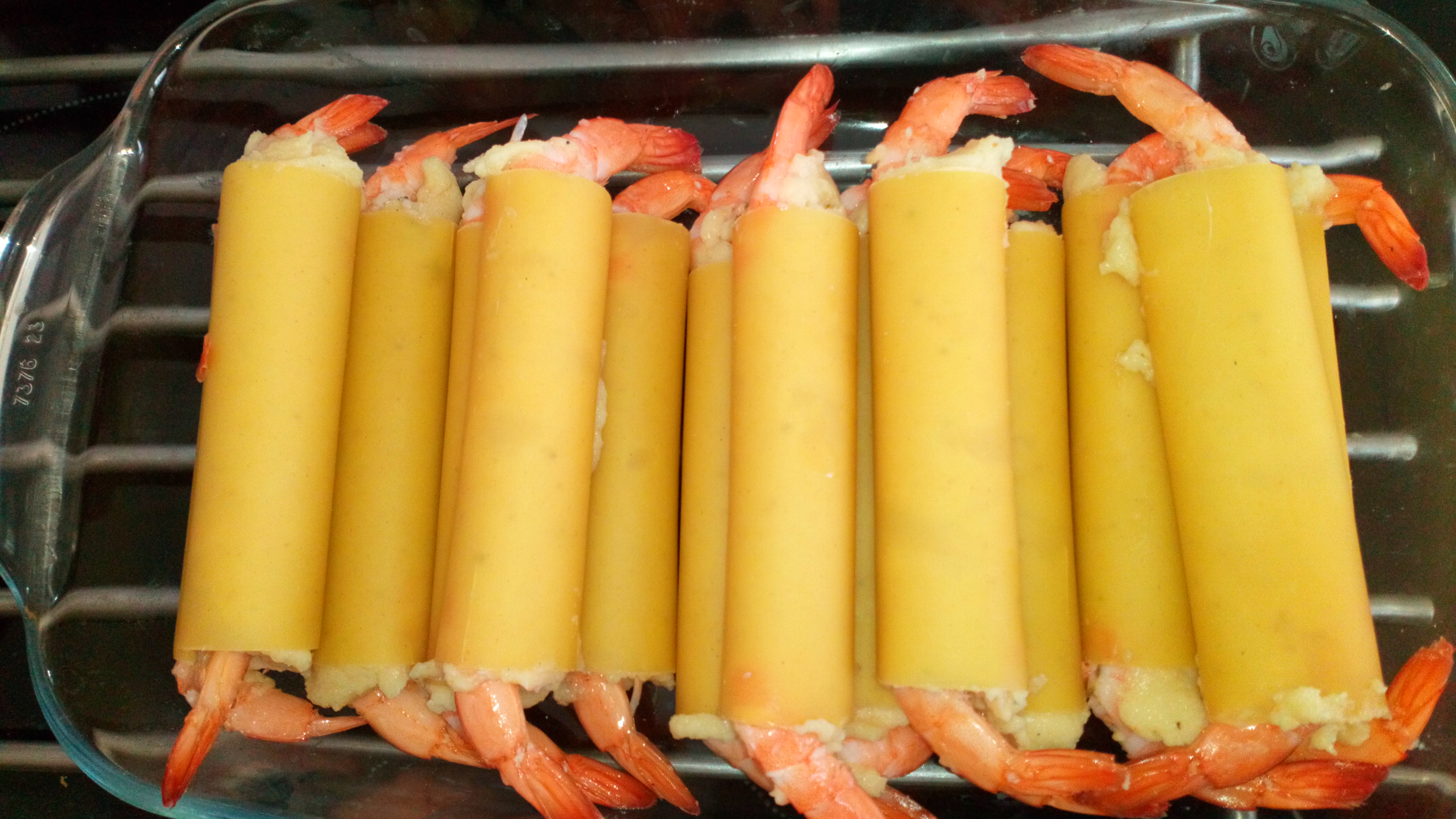 Mettre une crevette décortiquée à chaque extrémité en laissant dépasser la queue. Mettre le plat au frais. Put a peeled shrimp on each extremity and put in oven dish