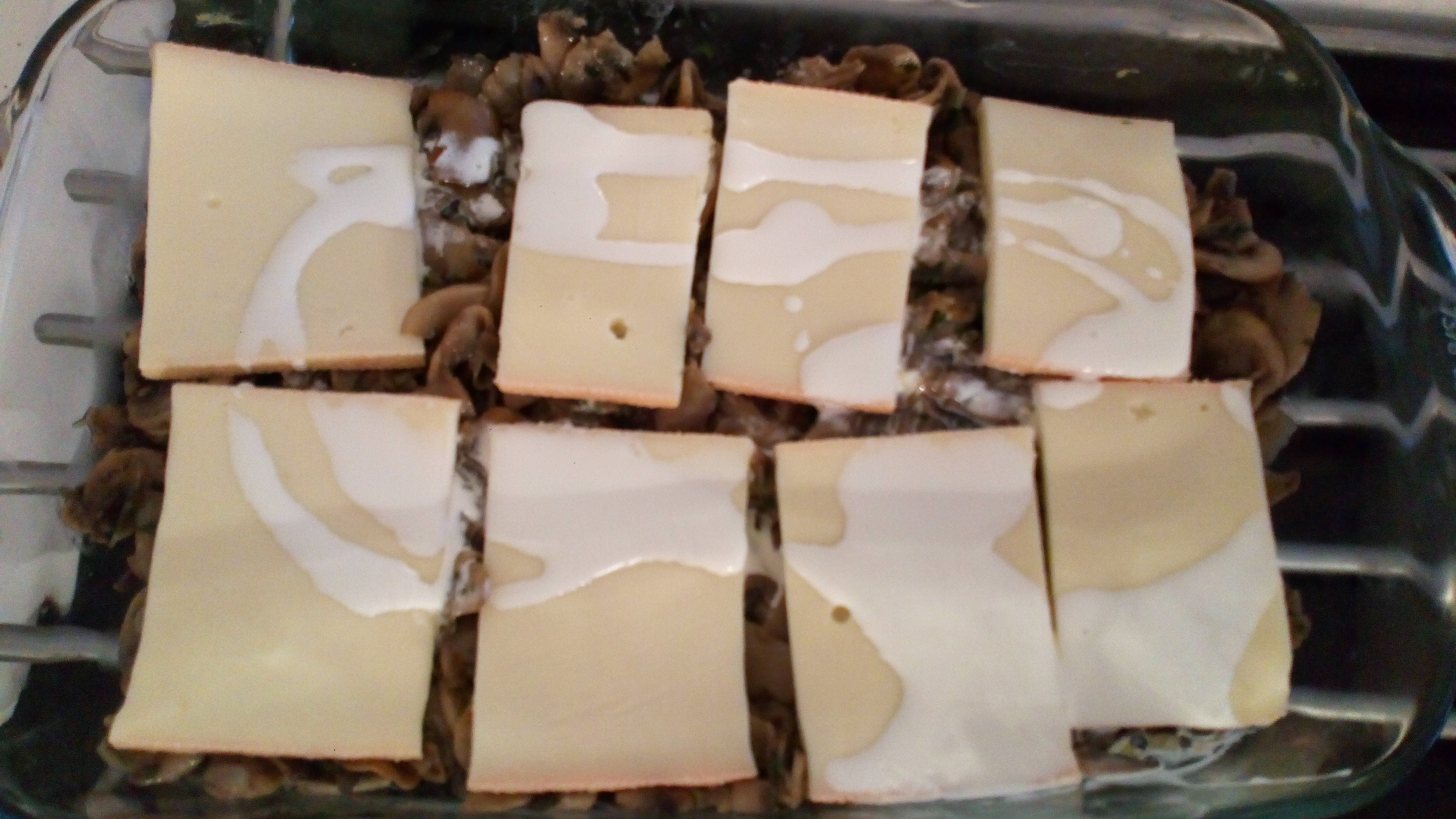 Mettre des tranches de fromage sur la surface des champignons, ajouter un petit de crème. Put slices of cheese on surface of mushrooms spread 5 cl cream