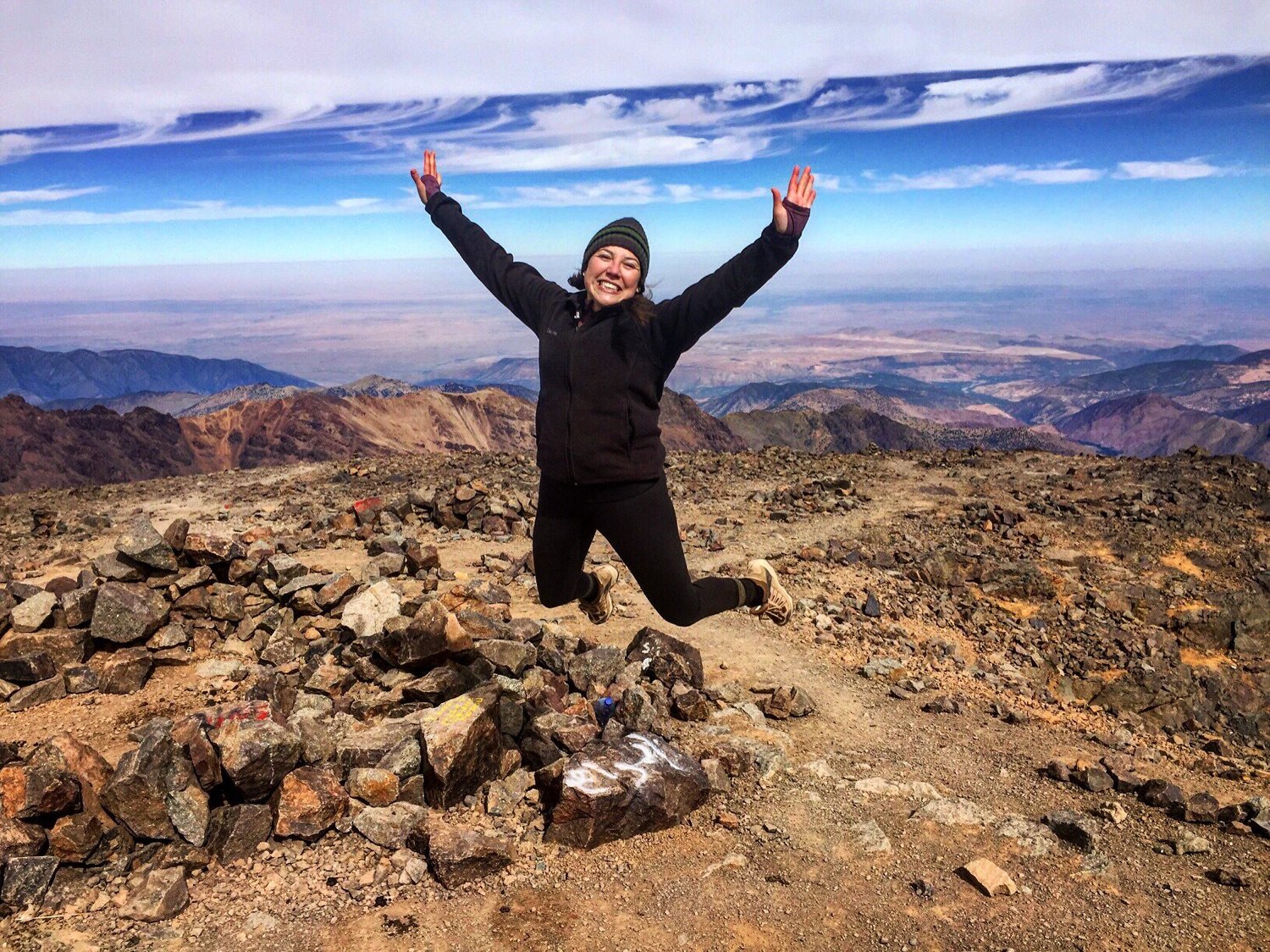 Lauren Bernal jumps at the top of Mount Toubkal, the highest point in the Atlas Mountains and Northern Africa, during her participation in Remote Year.