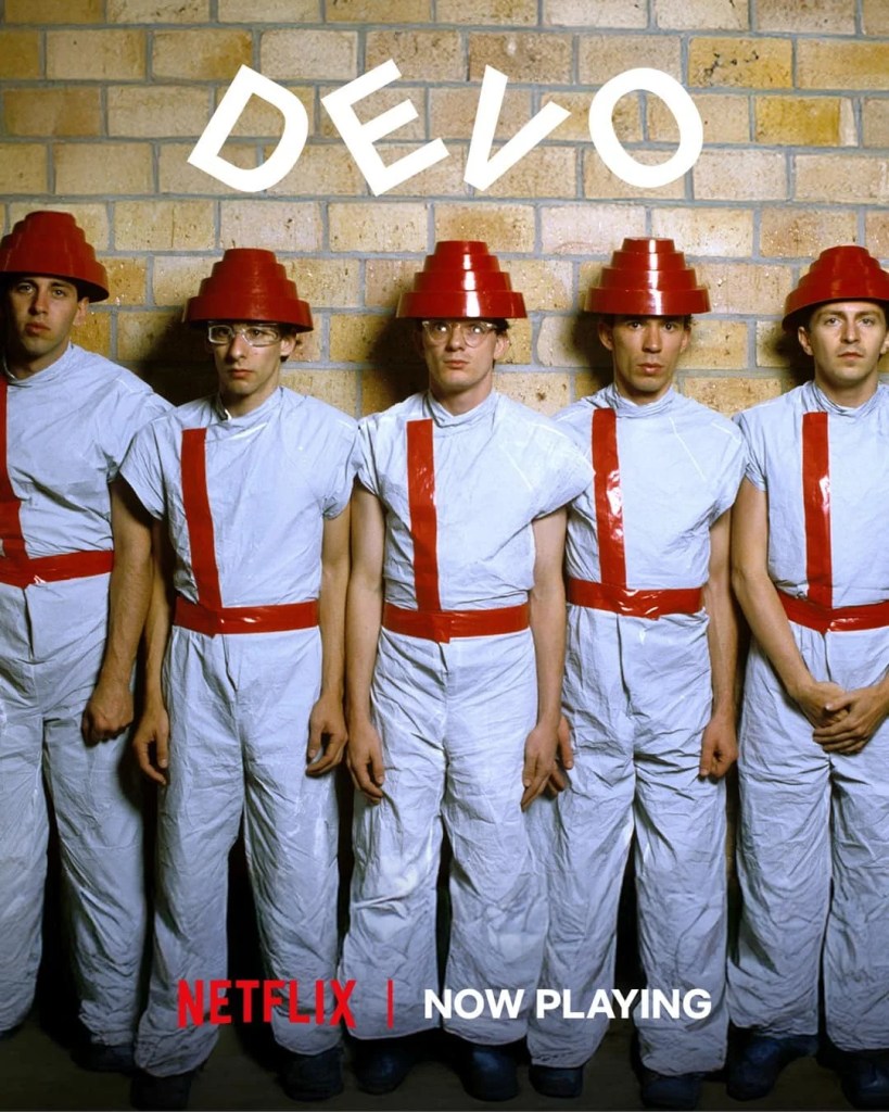 Netflix’s new DEVO documentary unravels the band’s bizarre journey from Akron to “Whip It,” revealing their prophetic vision of de-evolution and cultural rebellion.
