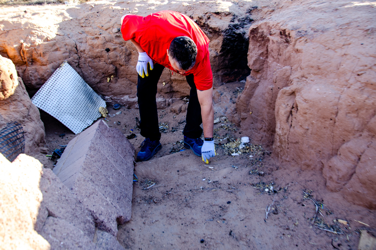Rio Rancho resident John Pierce points out a needle found at a homeless encampment near the Intel plant, known to some in the neighborhood as “the hole in the field.” Pierce said at least six people stay in a dug-out hole near the plant. (Jesse Jones)