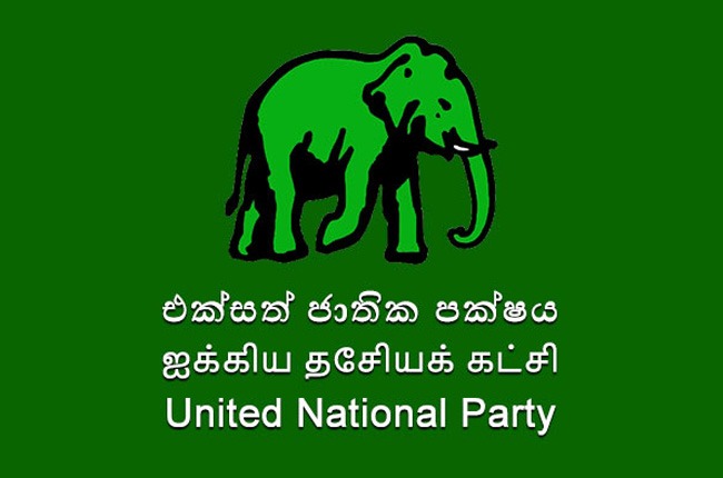 Green banner with a black elephant logo on a green background and the words United National Party in Sinhala, Tamil, and English.