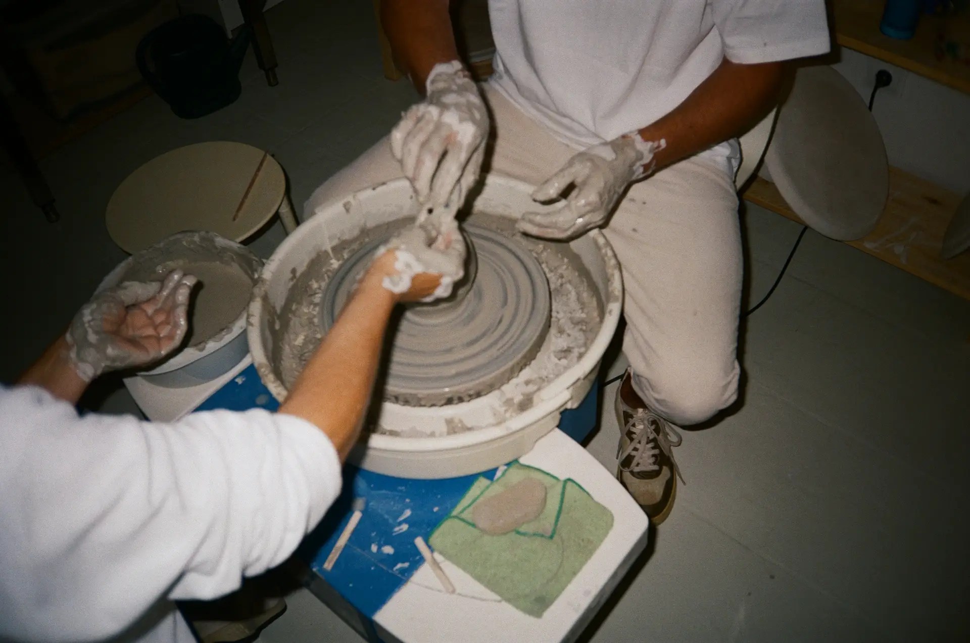 Hands shaping clay on the potter's wheel during a class in Sitges