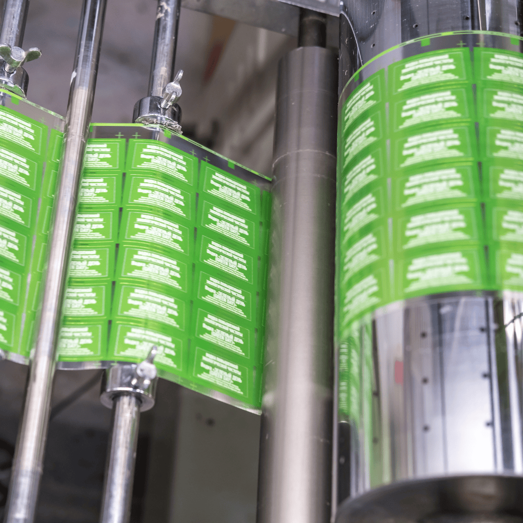 A label-making machine producing a roll of green labels.