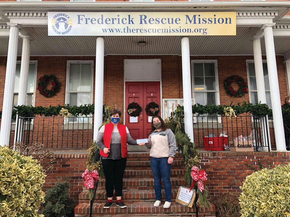 Sara donating money that her sales raised to the Frederick Rescue Mission.