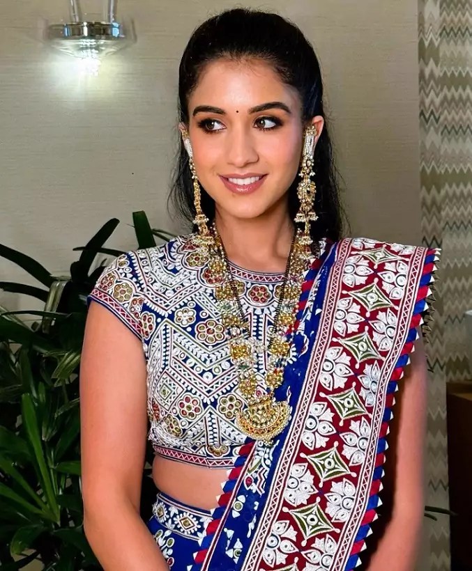 Radhika Merchant wearing a traditional embroidered lehenga with intricate mirror work and antique gold jewelry at Isha Ambani's Garba night, designed by Abu Jani Sandeep Khosla.