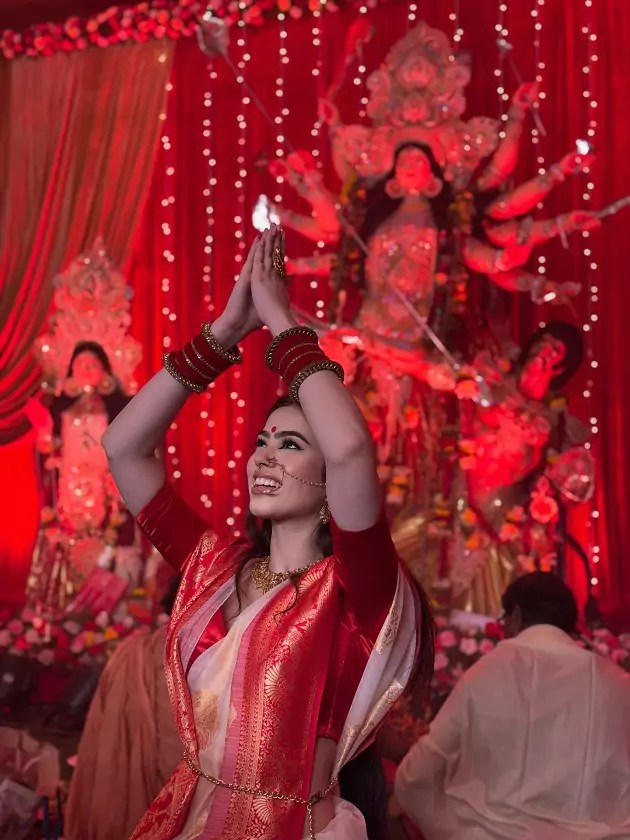 Arora dancing in a red saree during Durga Puja celebrations.