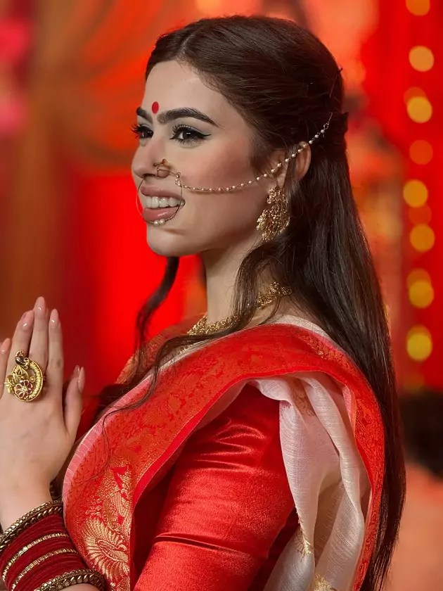 Riva Arora in red saree offering prayers during Durga Puja.