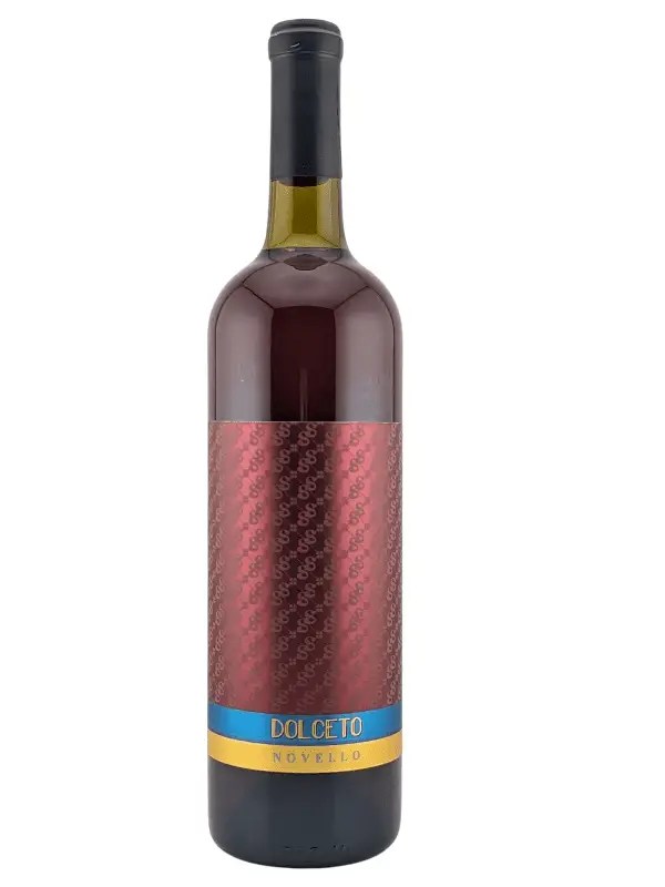 A bottle of Dolcetto Novello wine with a maroon patterned label and a blue and yellow band near the bottom. The bottle has a black cap and the wine inside appears to be red.