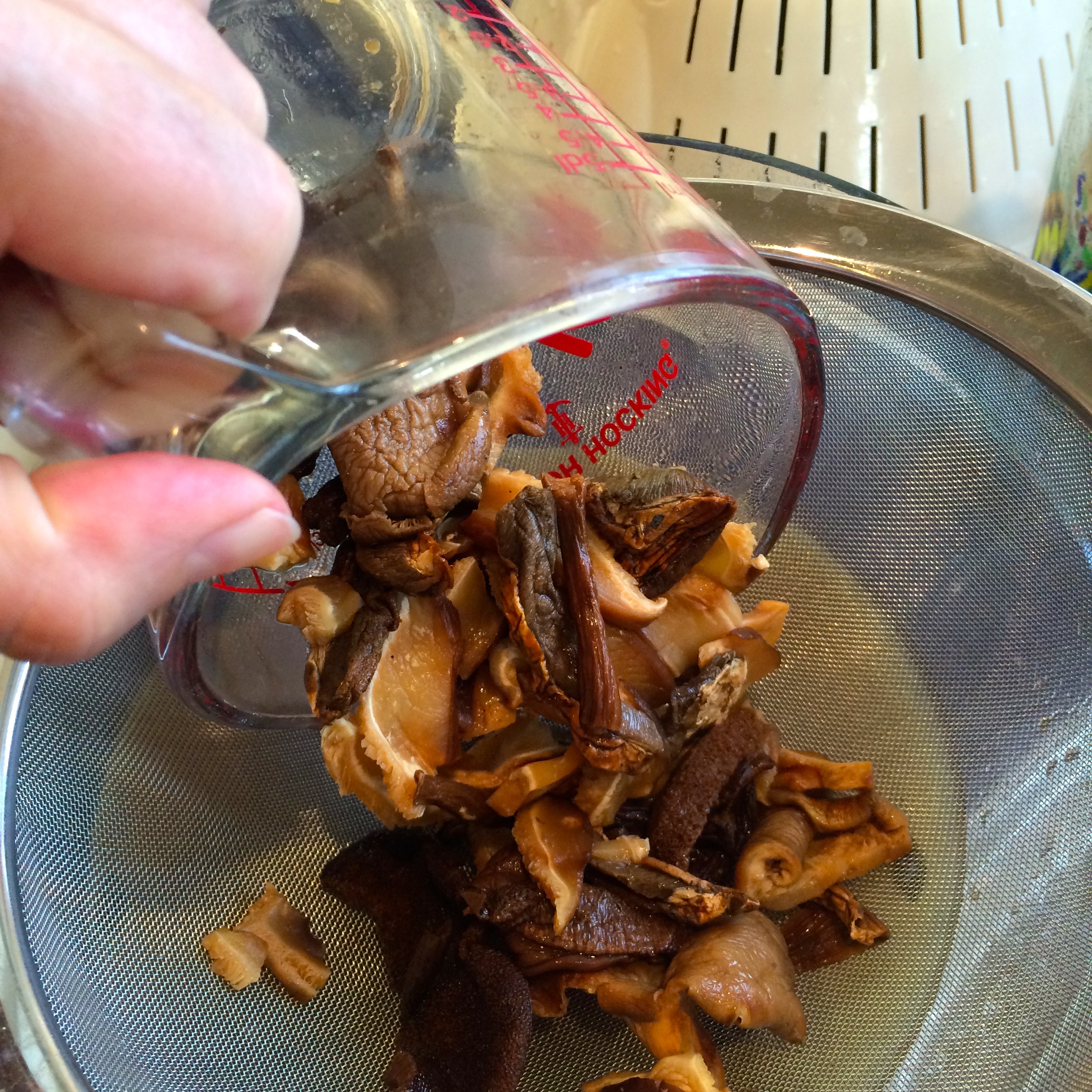 straining the reconstituted dried mushrooms - photo - Karen Anderson